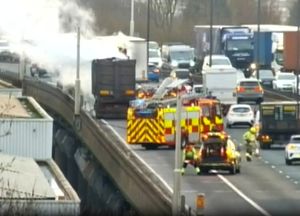 Smoke can be seen rising from the affected vehicle on the scene