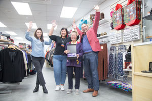 Sue celebrates in the shop with fellow volunteers