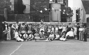 The children put on a show in the shadow of the school's water tank and with a piano at the top of some steps.