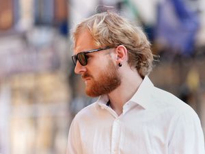 Side view of William Heggs, wearing white shirt and sunglasses