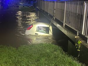 The car trapped in fast-flowing water in Hall Green. Credit: West Midlands Police.