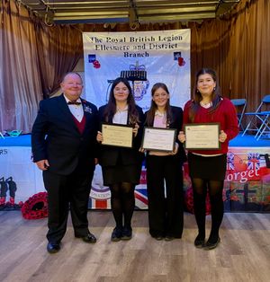 Legion branch president Ian Williams presents a certificate of thanks to singers Mini, Ellie and Tabitha.
