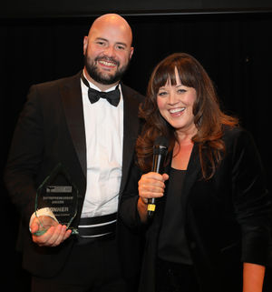 Hilltop Honey founder Scott Davies receives the Entrepreneurship Award from Powys Business Awards host Claire Summers.