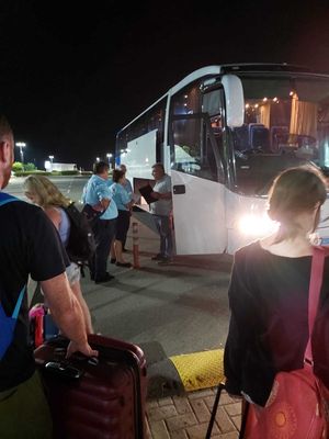 Passengers wait to board a coach late at night after their cancelled flight. Photo: Chris Smith