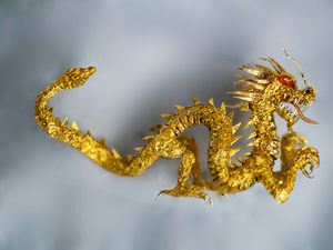 Supporting image for story: Micro artist Willard Wigan's latest artwork – a golden dragon smaller than a matchstick head