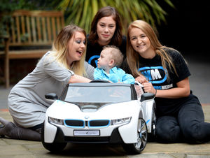 Cain Highfield, aged 2, tries out his new car with mum Zoe, left, Abbey Williams and Lauren Woodhall from West Midlands Media, Wolverhampton 