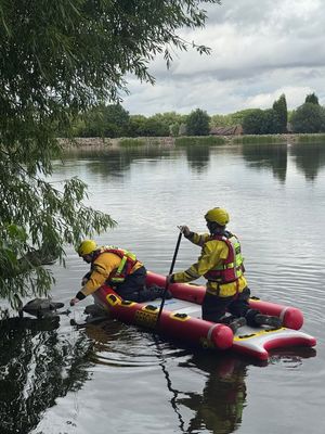 Telford firefighters at Trench Pool, where they were helping a young swan which had become trapped in wire. Photo: Shropshire Fire and Rescue 