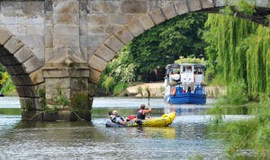 A couple enjoy a rowing boat on the river as the Sabrina boat approaches