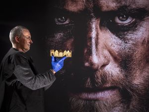 Man holding a crown, with an image of a fictional Macbeth behind him