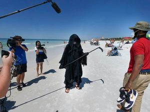 Supporting image for story: Florida lawyer dresses as grim reaper on beach in protest at reopening