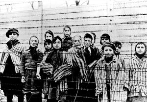A picture taken just after the liberation by the Soviet army in January 1945, shows a group of children wearing concentration camp uniforms behind barbed wire fencing in the Auschwitz  concentration camp. 