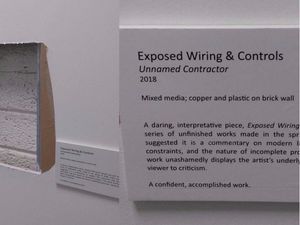 Supporting image for story: This man stuck a museum label next to a hole in his office wall and turned it into modern art