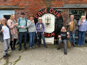 Barbara Jones of Babbinswood Farm (seated) and members of the community benefit society toast the £100,000 milestone with milk from the cow and calf dairy.