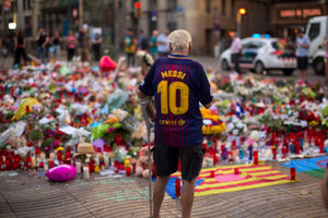 A man in a Lionel Messi Barcelona shirt pays tribute to the victims