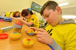Cody Peake-Coombes, 13, concentrates on decorating a cake


