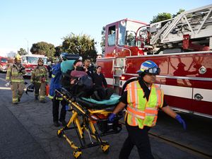 A woman is carried on a stretcher near the site of a plane crash