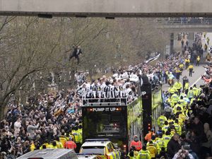 A Newcastle United fan watches on in a tree as the players pass by aboard an open top bus during the Carabao Cup trophy parade in Newcastle