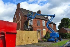 The scene on Wednesday as workers began removing roof tiles from the house