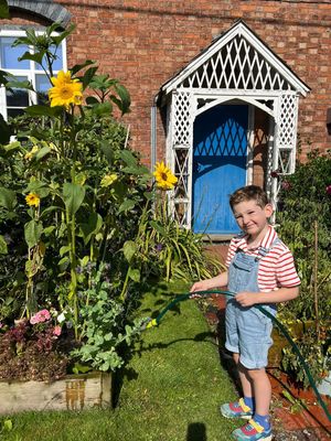 Master Rupert Worton watering the flowers outside his primary school 