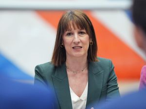 Chancellor Rachel Reeves sitting in front of a Union flag in a green jacket