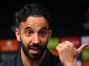Ruben Amorim points to his left as he speaks at a press conference