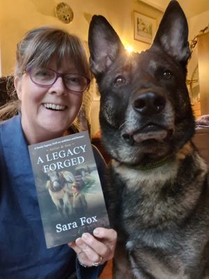 Debut author Sara Fox with her 'grandfluff' Kane, holding her copy of A Legacy Forged.