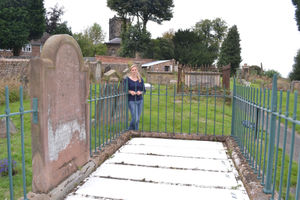 Alison Vermee with the headstone commemorating the Nine Men of Madeley in the town's St Michael's Church