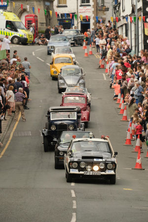 Vintage vehicles coming through the street before the main procession. Image by Andy Compton