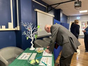 The Mayor of Walsall, Councillor Anthony Harris, writes a message for the memory tree at Willenhall CHART Centre's Covid-19 memorial event.