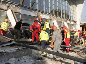 Rescue service workers inspect rubble at the scene of the canopy collapse