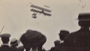 A crowd watches an early aircraft in flight at the 1910 Bournemouth event 