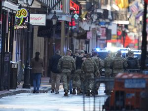 Military personnel walk down Bourbon Street in New Orleans