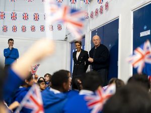 Primary school children greet Ross Kemp and Dame Kelly Holmes surrounded by bunting and Union flags