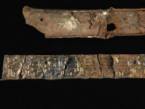 A section of the reconstructed helmet band, depicting a frieze of warriors