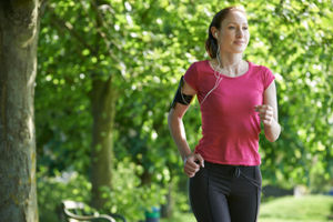 Young woman listening to music while running. 