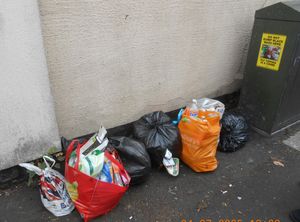 Bags of dumped household waste which had been left next to a warning poster