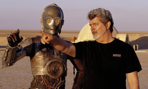 On location in the Tunisian desert, Director George Lucas directs actor Anthony Daniels, who plays the robot C-3PO, in Star Wars II: Attack of the Clones
