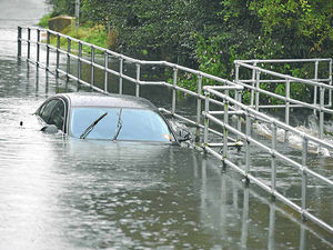 Supporting image for story: Car is left marooned as floods hit region
