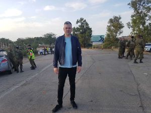 Peter Madeley stands at a road block near the Gaza border where life goes on amid waves of violence