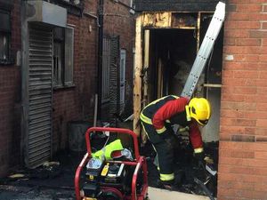 A firefighter cleans up the debris after the blaze.