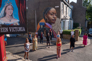 Actors and visual artist Dreph with his mural painted on the side wall of the Beales' house
