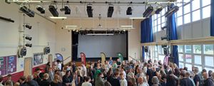 Students with their parents and carers gathering in the school’s hall to collect their results