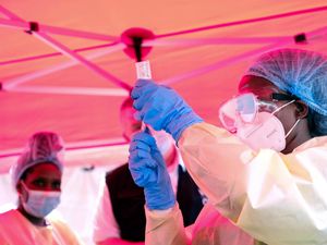 A health worker prepares to administer a vial of a vaccine against the Sudan strain of Ebola, during a trial at Mulago Referral Hospital in Kampala, Uganda