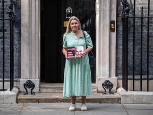 Heather Cornelius stands outside 10 Downing Street with a sign reading 'Free Ryan Cornelius'
