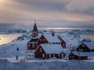 A woman walks near a church in Nuuk, Greenland,