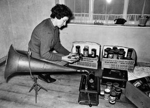 January 1969. 'We tasted the delightful magic of the phonogram on a rain-filled afternoon at Dudley. Thomas Edison in 1877 invented the first machine to record and reproduce sound and called it a phonogram. The machine we tried, at the home of Mr and Mrs J. Nock, of Garden Walk, Lower Gornal, was new at about the turn of the century and must have been the status symbol of its time... This is perhaps the first time this machine has been played in 40 to 50 years...' The story does not say who the lady on the picture is but it is Mrs Nock as written on the print is 'Mrs I. (sic) Nock and cylinder phonograph.' 