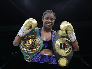 Caroline Dubois holds up her fists and belts after winning