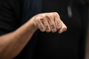 An Ozzy Osbourne-themed tattoo on the hand of music fan Raphael Lima as he arrives to attend British rock band Black Sabbath's "Back to The Beginning" concert, Ozzy Osbourne's final ever gig as Black Sabbath's frontman at Villa Park in Birmingham, central England on July 5, 2025. Osbourne, who revealed in 2020 that he has Parkinson's disease, will join Tony Iommi, Geezer Butler and Bill Ward for the all-day "Back To The Beginning" show in Birmingham, central England, where the heavy metal giants formed in 1968. (Photo by Oli SCARFF / AFP) (Photo by OLI SCARFF/AFP via Getty Images)          