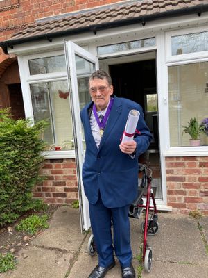 Roger Horton wearing his Freeman Badge and holding his ceremonial scroll