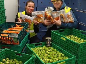Amy Howard and Sam Pitch from Shrewsbury Food Hub with trays full of leftover Christmas food
